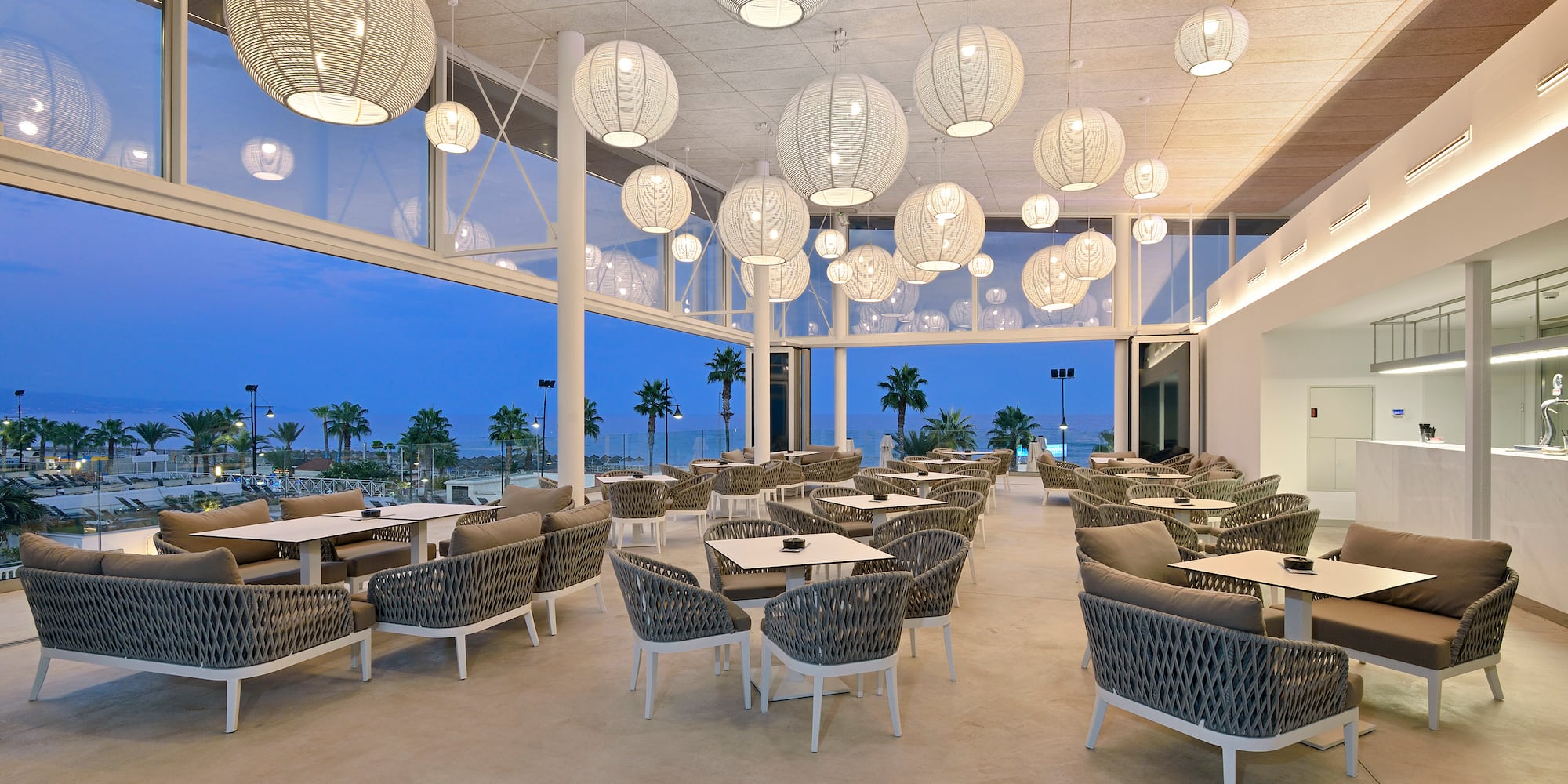 a room with tables and chairs and a large window