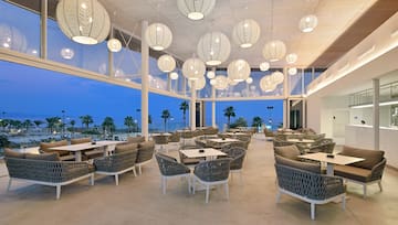 a room with tables and chairs and a large window