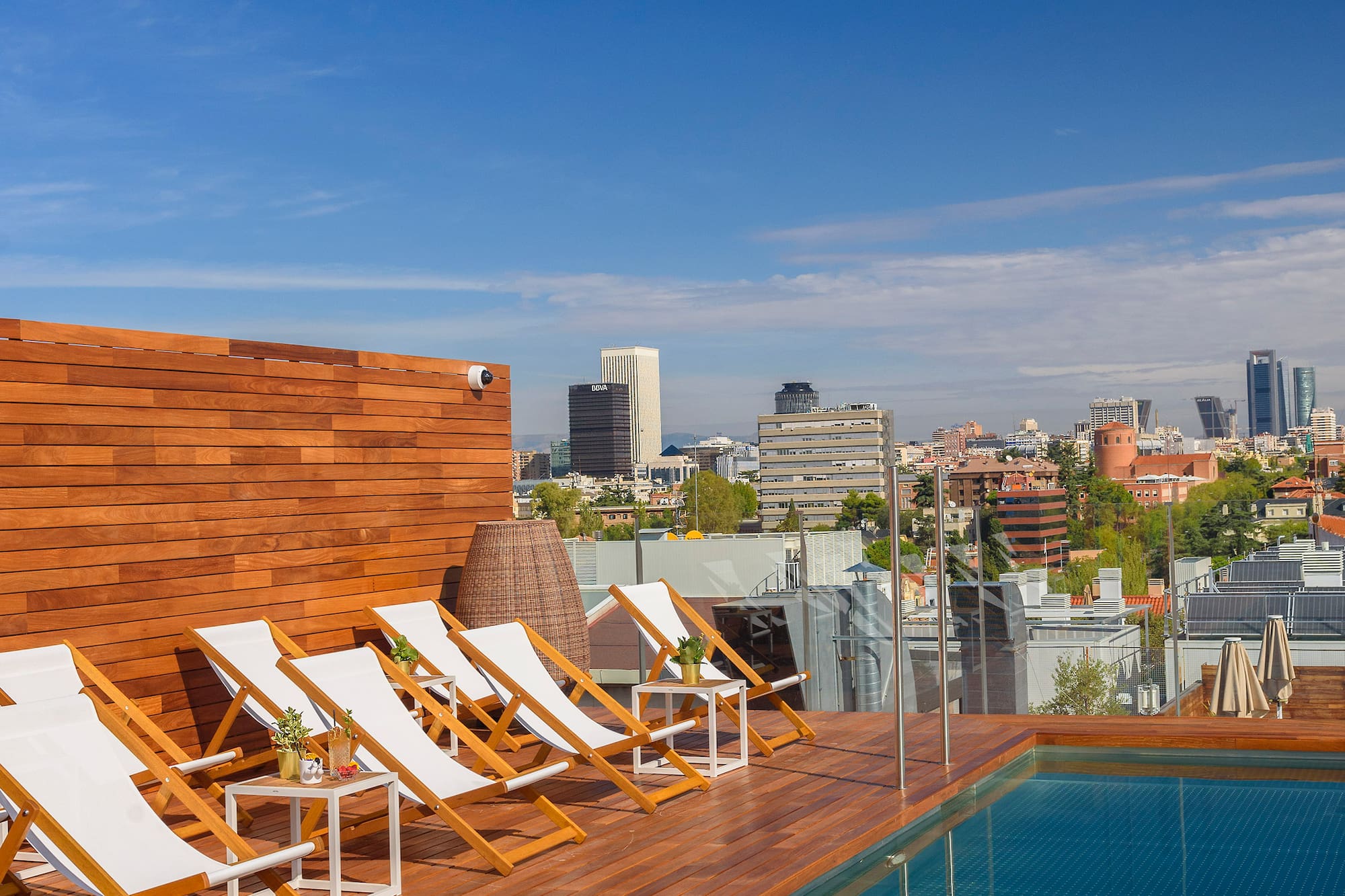 a pool with chairs on a rooftop
