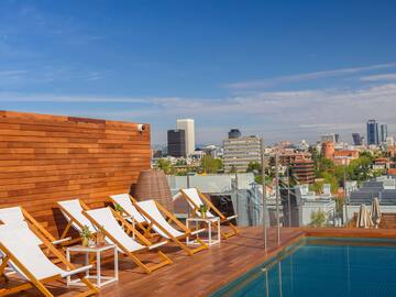 a pool with chairs on a rooftop