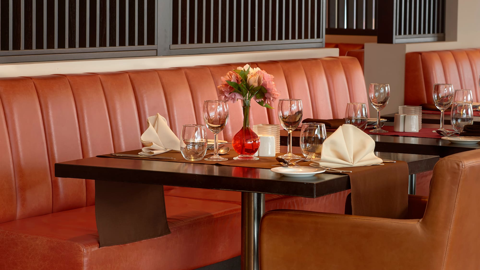 a table with a vase of flowers and glasses on it