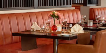 a table with a vase of flowers and glasses on it