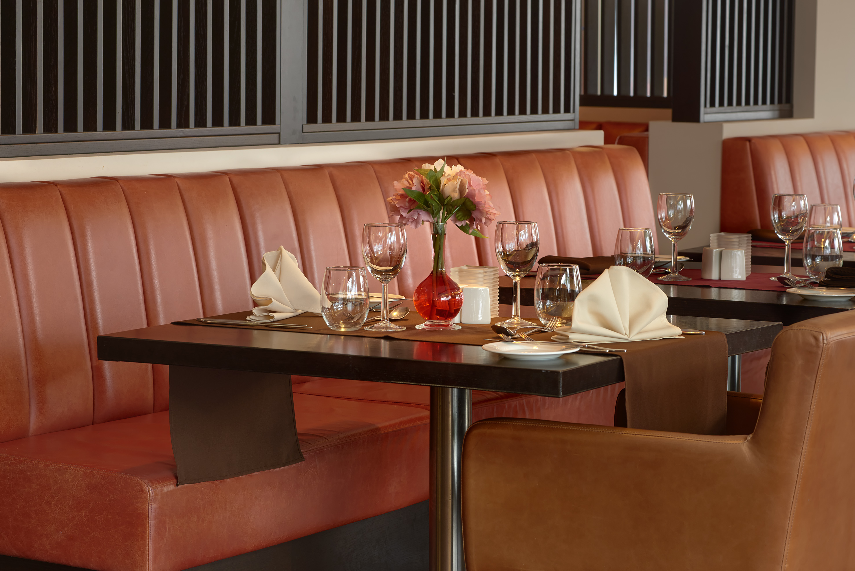 a table with a vase of flowers and glasses on it