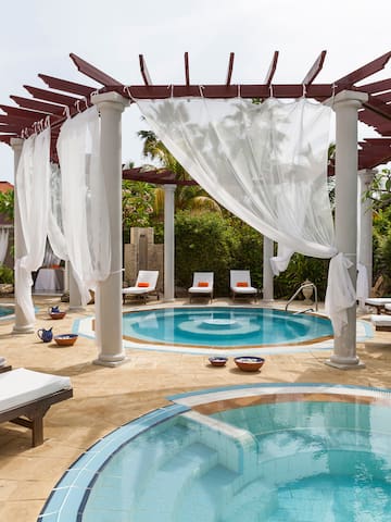 a pool with a gazebo and chairs