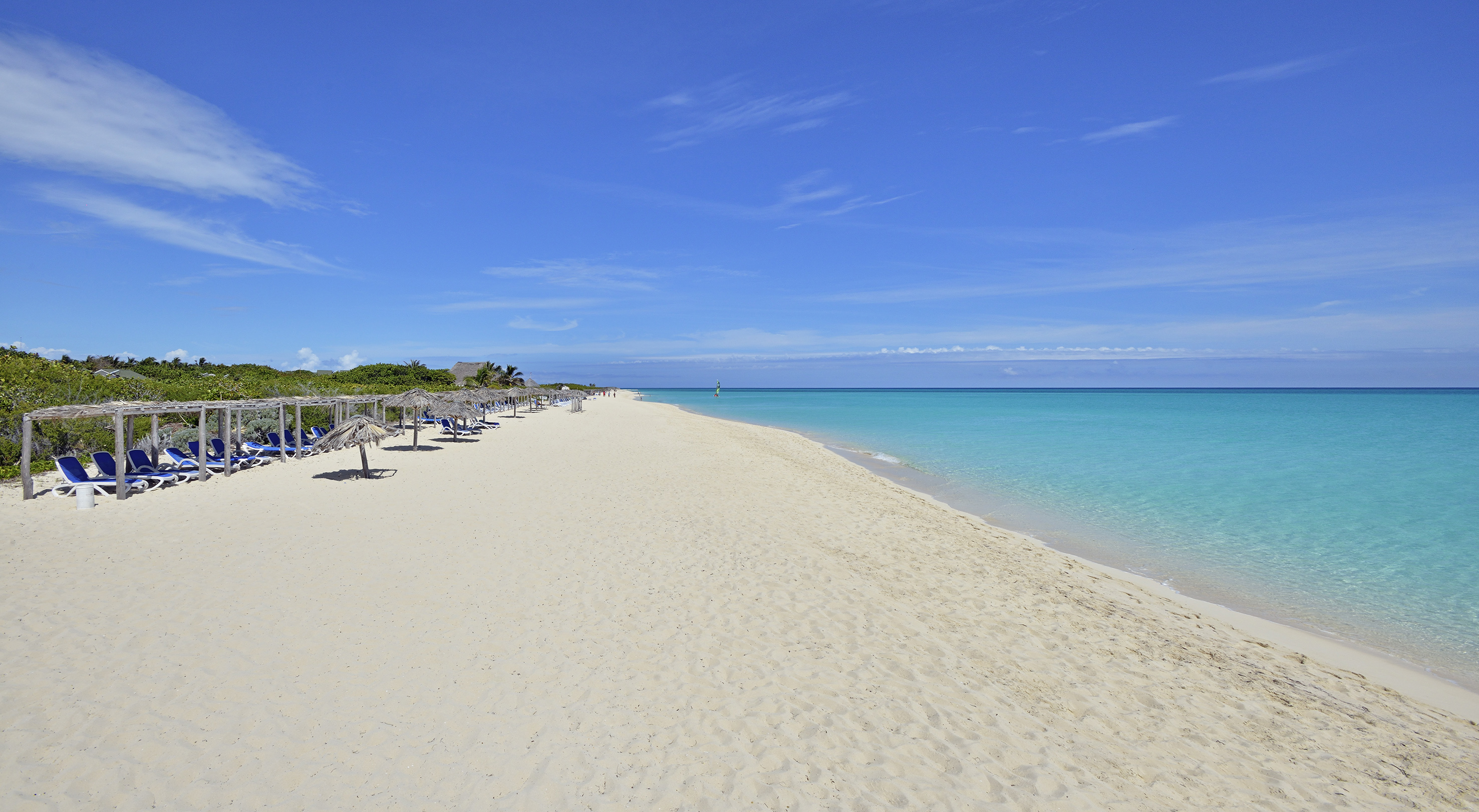 a beach with umbrellas and chairs