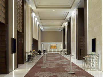 a long hallway with a carpeted area and a television