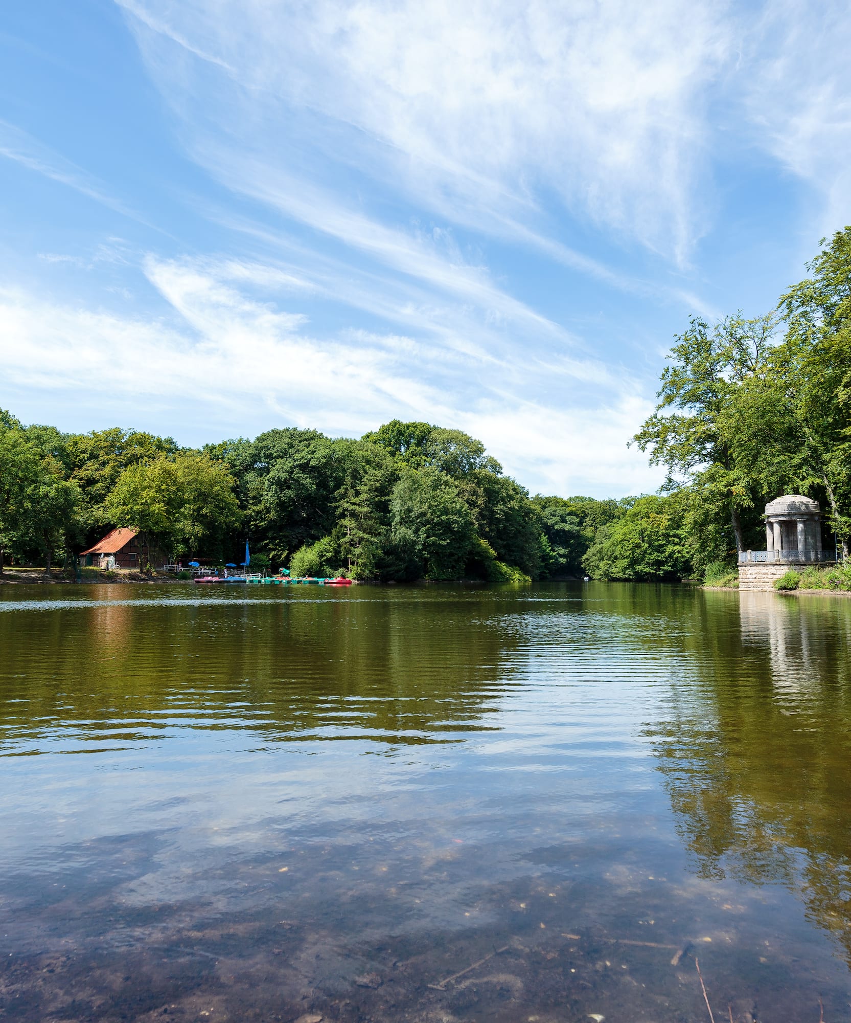 a body of water with trees and a gazebo