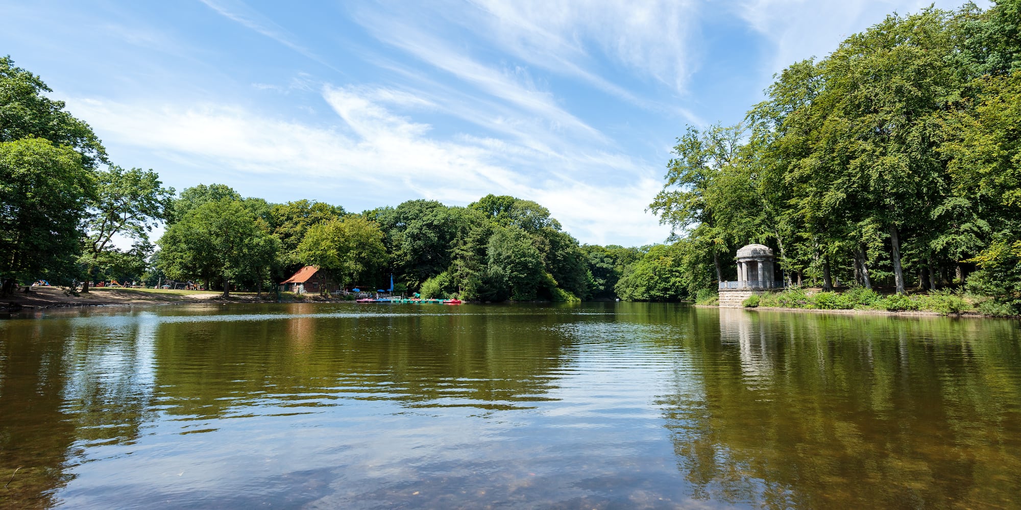 a body of water with trees and a gazebo