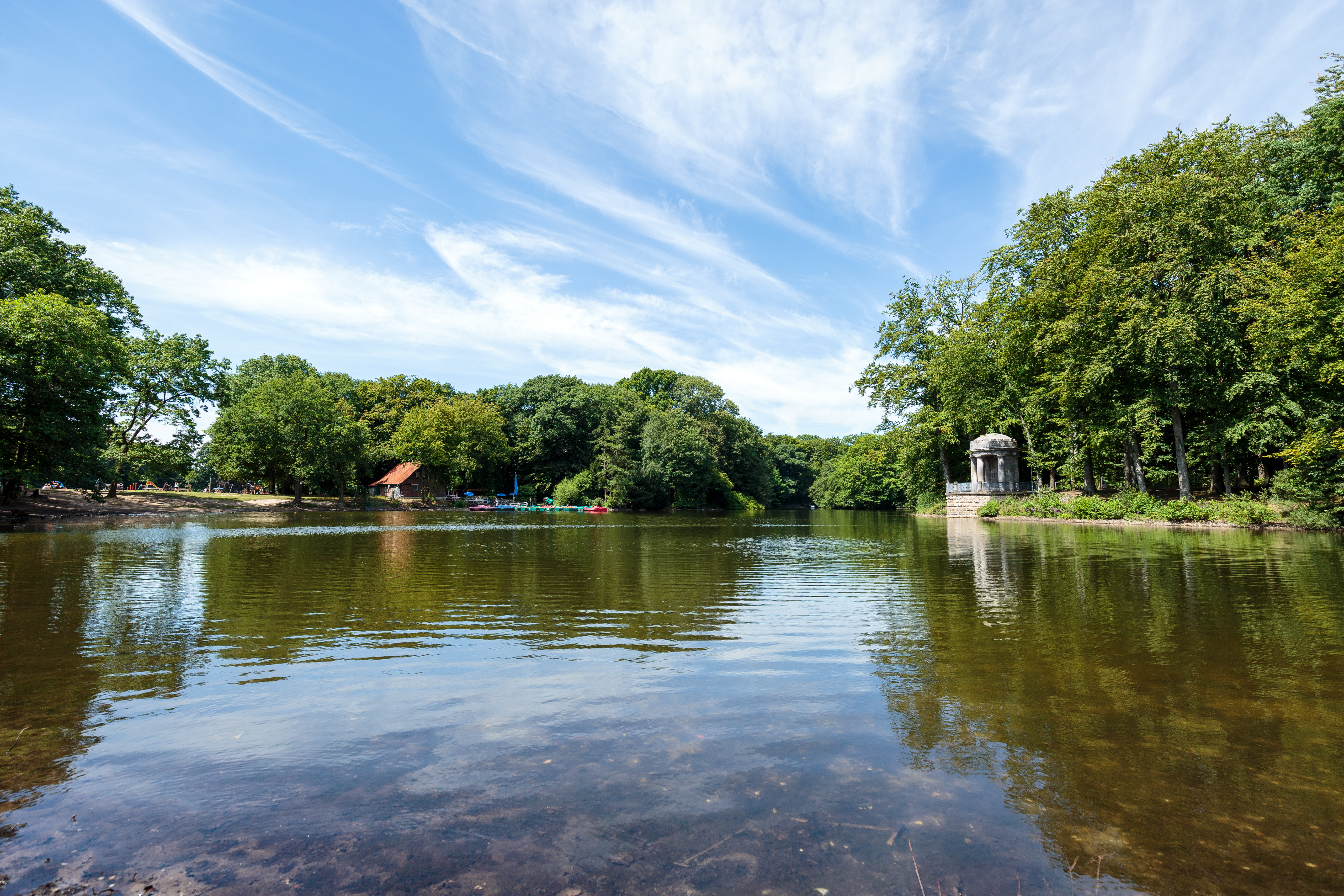 a body of water with trees and a gazebo