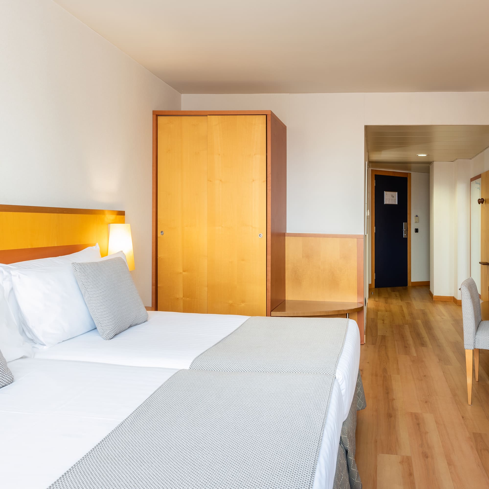 a room with two beds and a wood floor