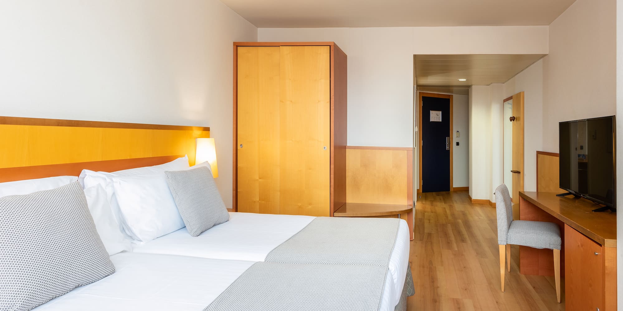 a room with two beds and a wood floor