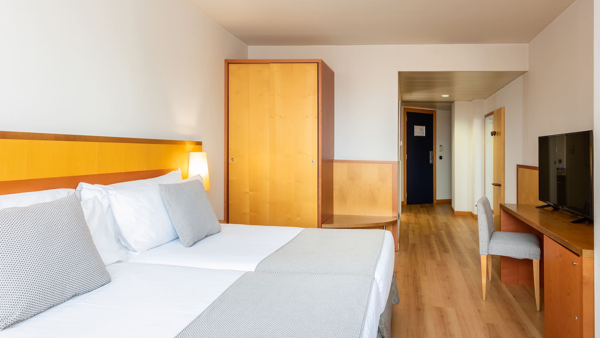 a room with two beds and a wood floor