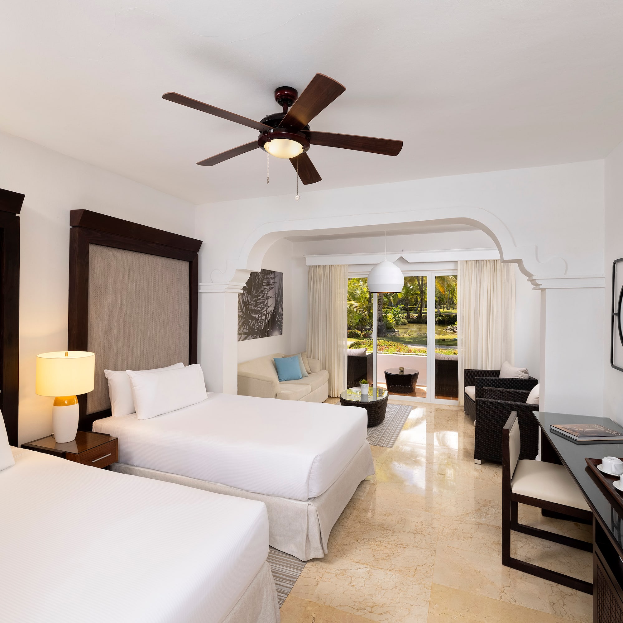 a room with two beds and a ceiling fan