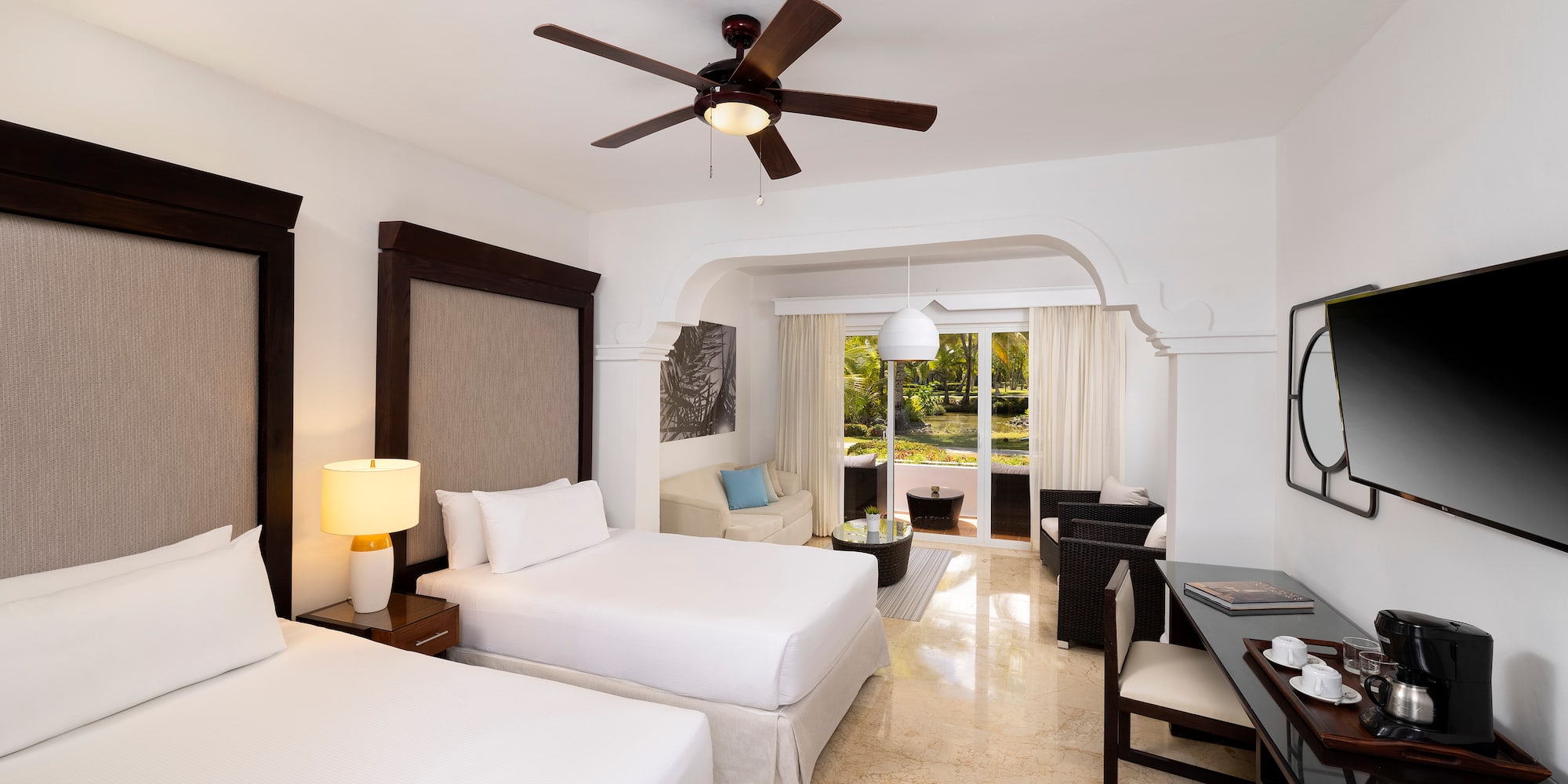 a room with two beds and a ceiling fan