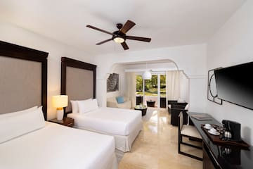 a room with two beds and a ceiling fan