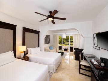 a room with two beds and a ceiling fan