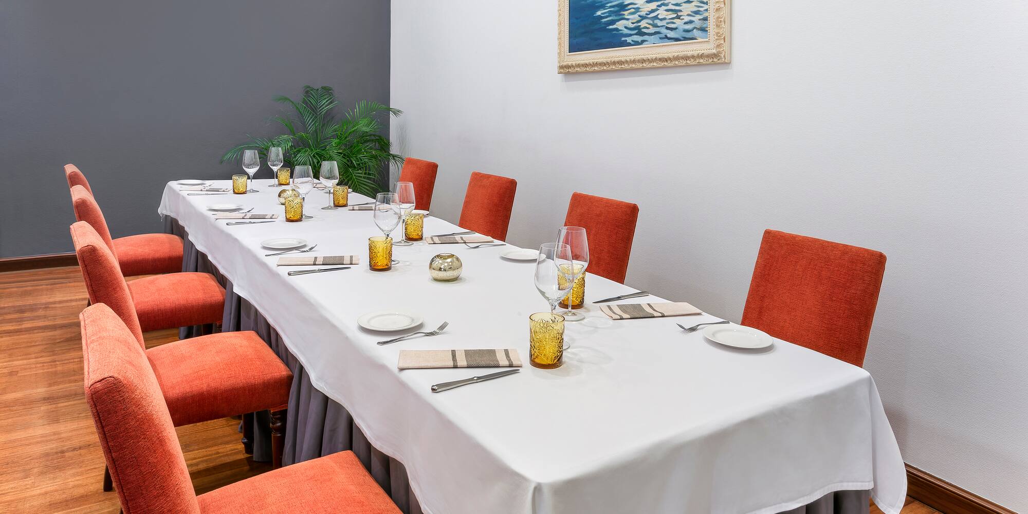 a long table with chairs and glasses on it