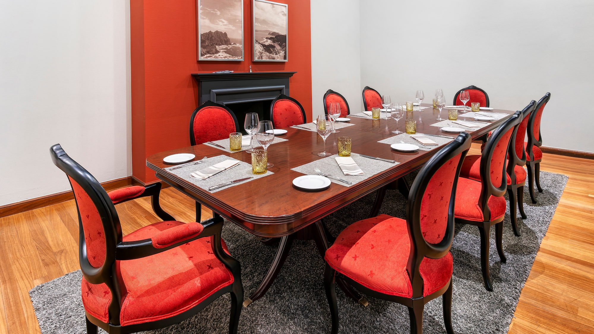 a table with red chairs and a fireplace