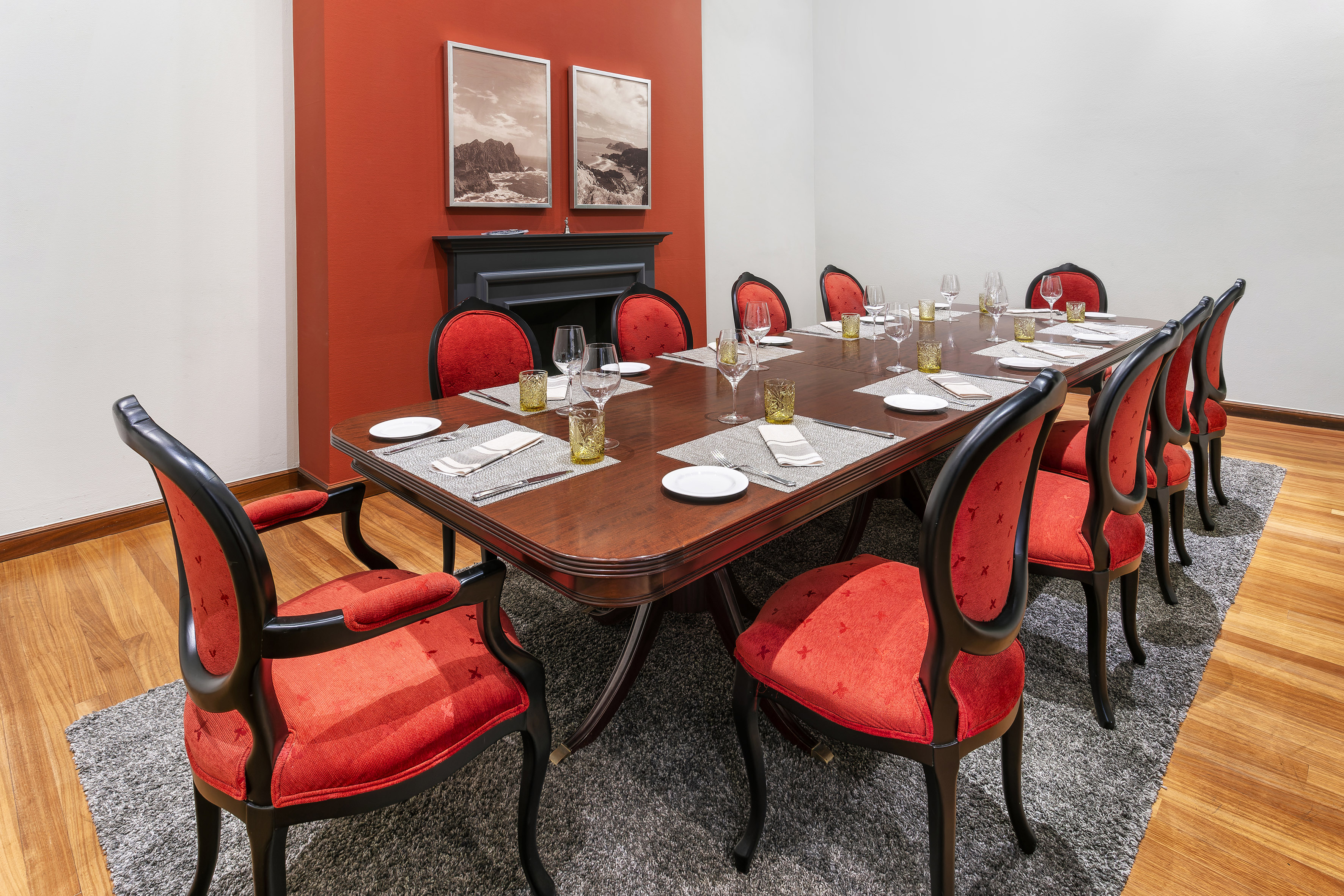 a table with red chairs and a fireplace