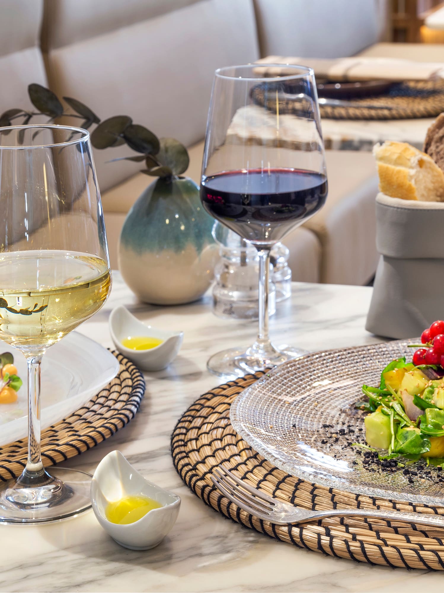 Gourmet fish and avocado salad with white and red wine at a restaurant.