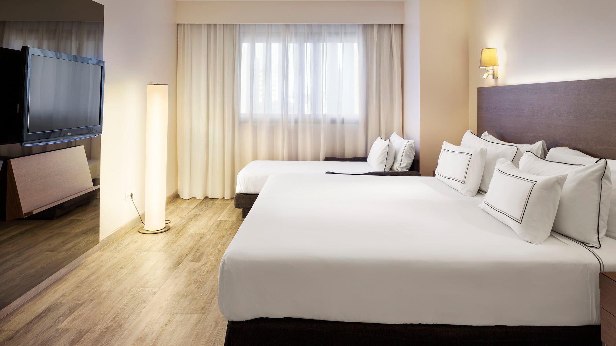 a room with two beds and a lamp