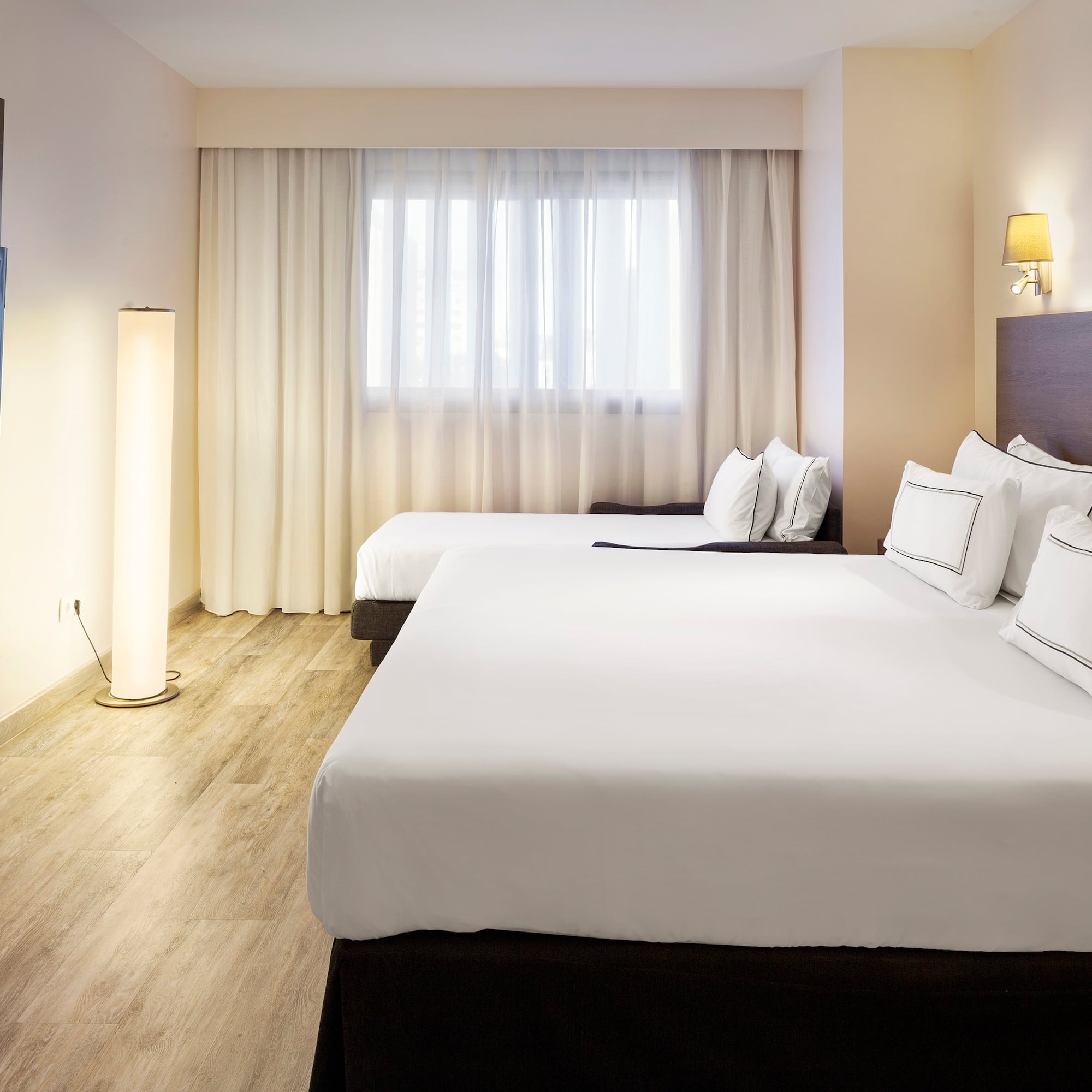 a room with two beds and a lamp