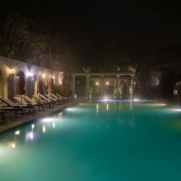 a pool with chairs and a stone wall