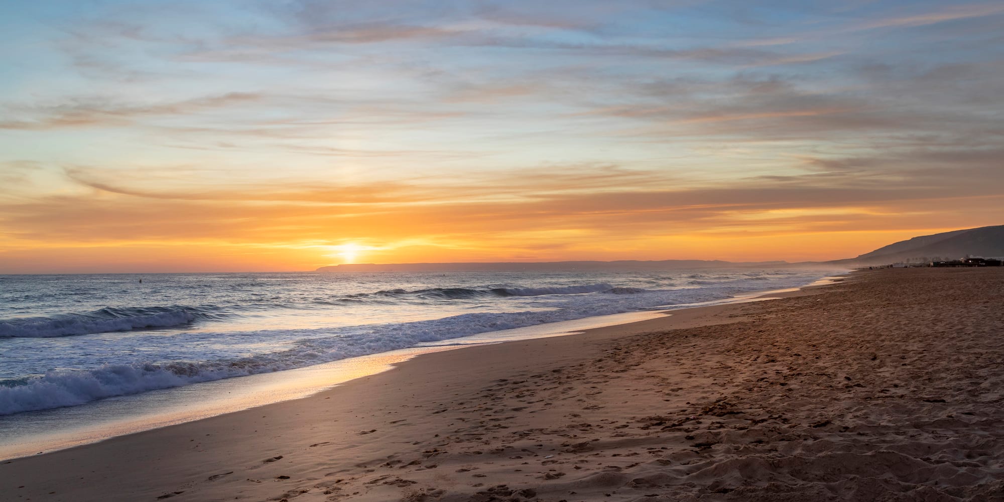 a beach with waves crashing on the shore