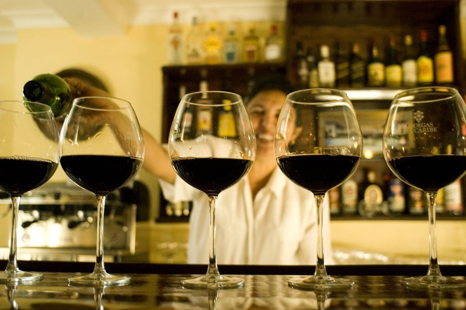 a row of wine glasses on a bar
