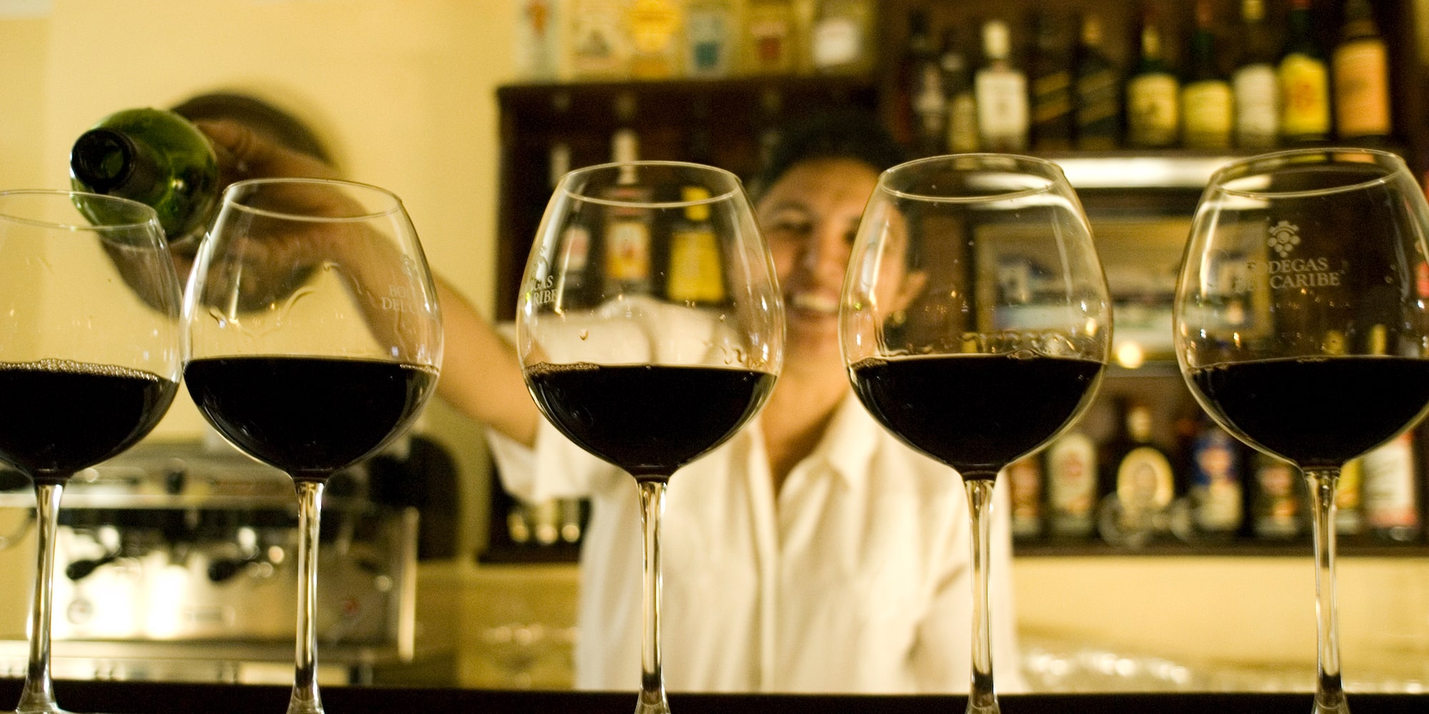 a row of wine glasses on a bar