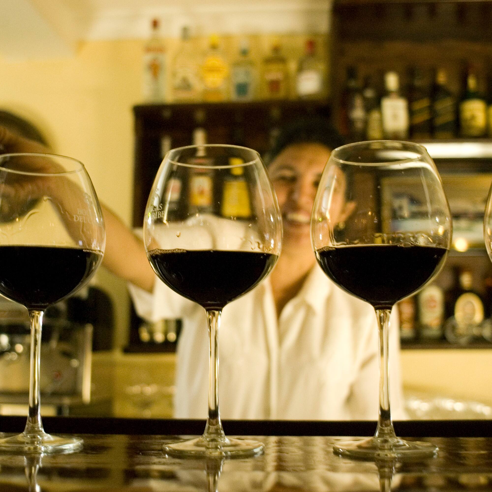 a row of wine glasses on a bar