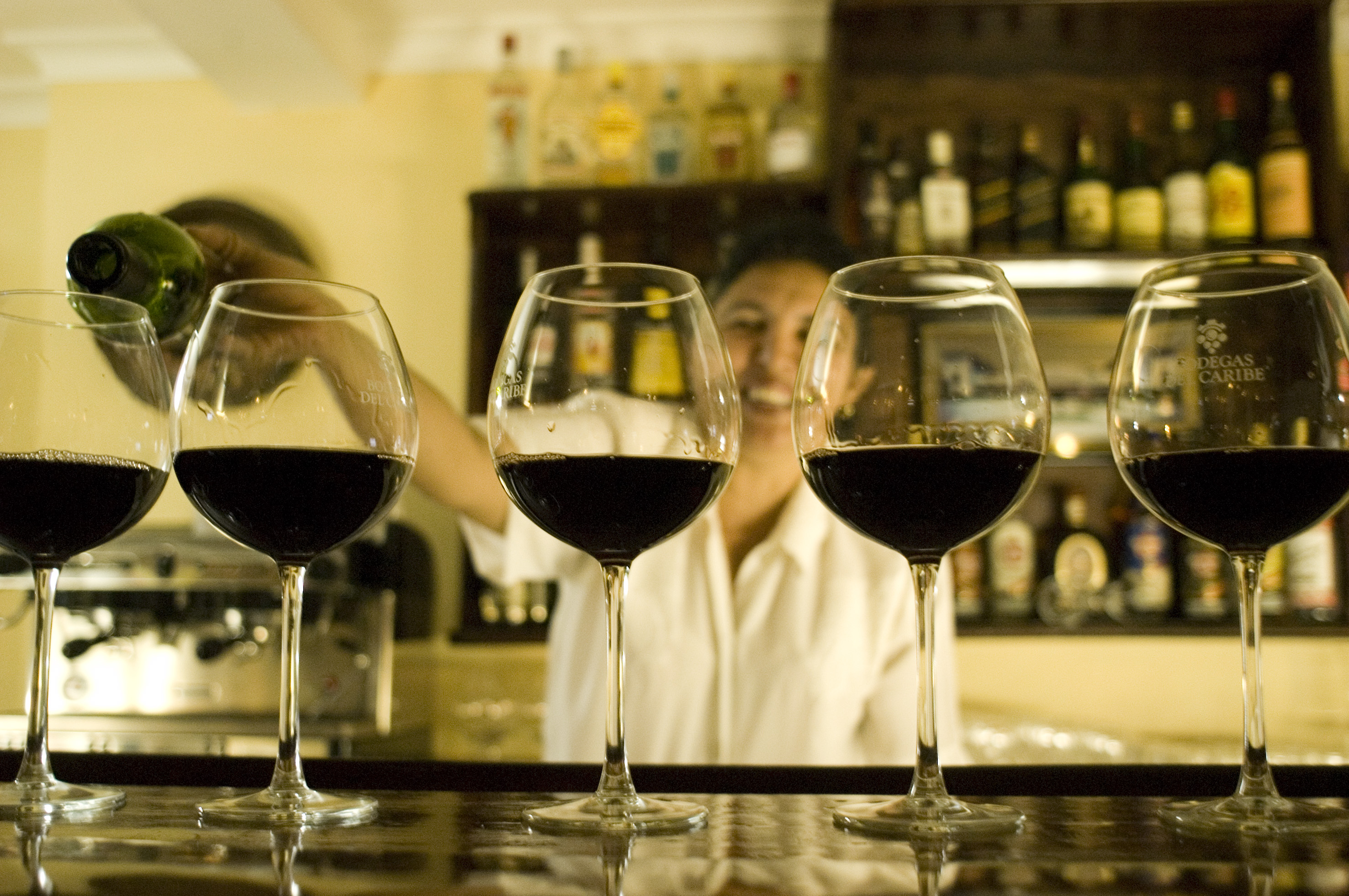 a row of wine glasses on a bar