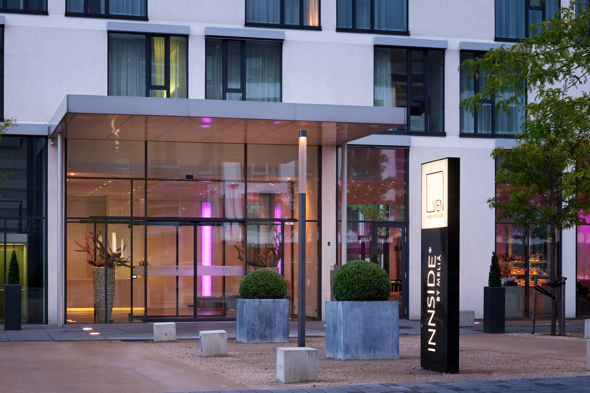 Modern Innside by Melia hotel exterior with glass entrance and Luven restaurant sign.