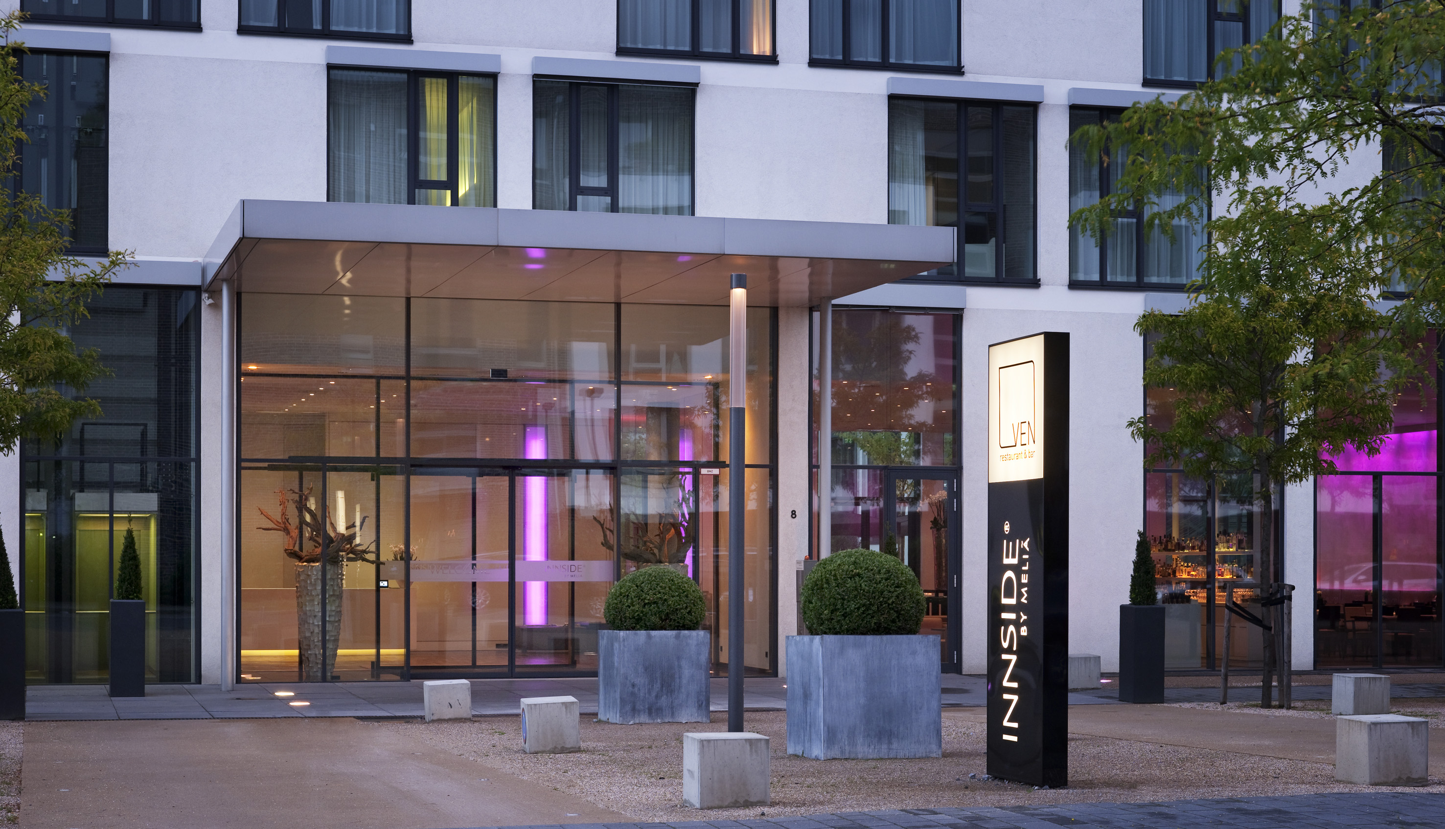 Modern Innside by Melia hotel exterior with glass entrance and Luven restaurant sign.