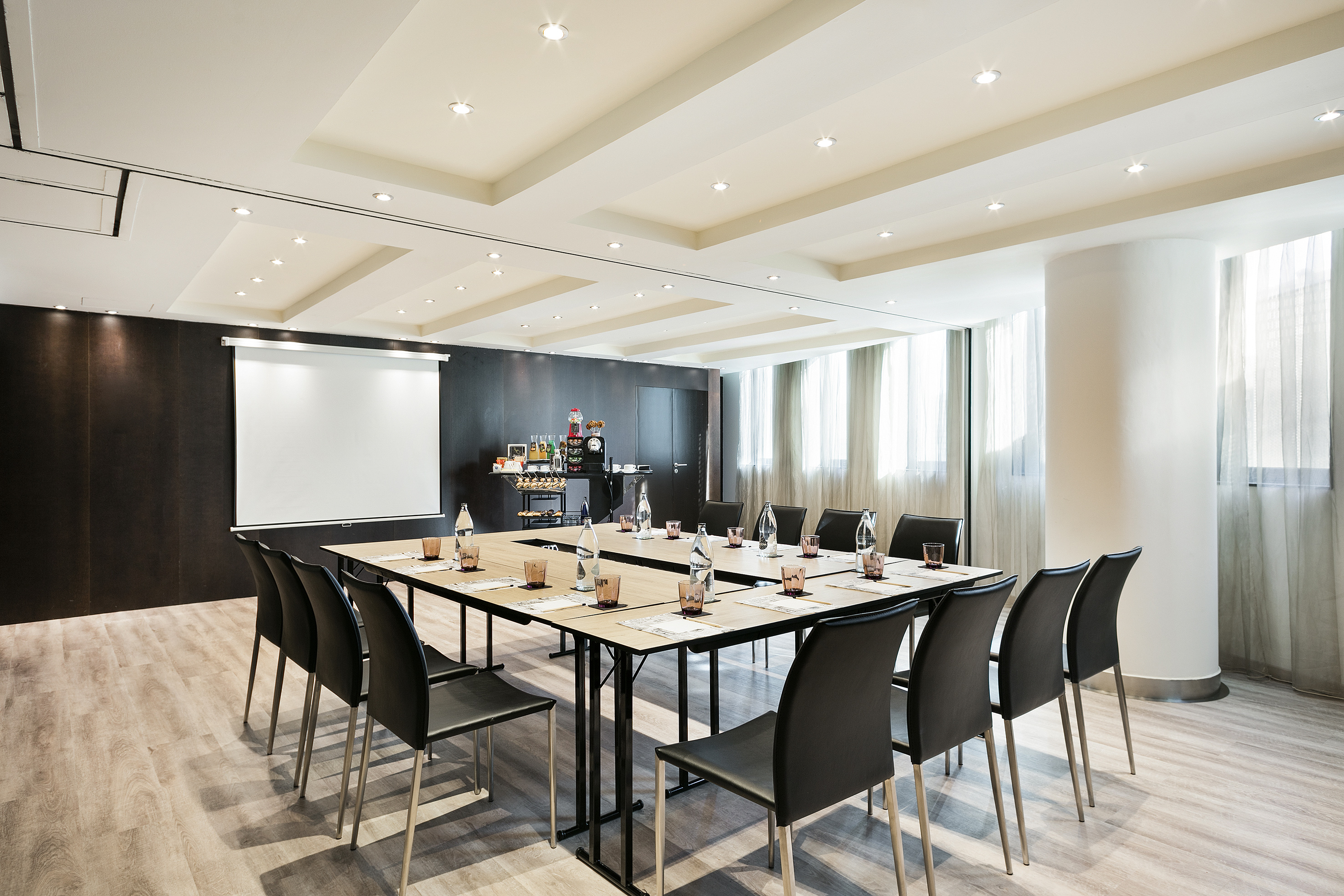 Modern conference room with U-shape table, projector, and refreshment station. - NOVA ICARIA - فندق برشلونة كوندال مار(Condal Mar) المنتسب لـ Melia, برشلونة