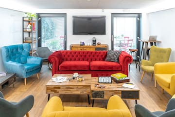 a room with a red couch and blue chairs