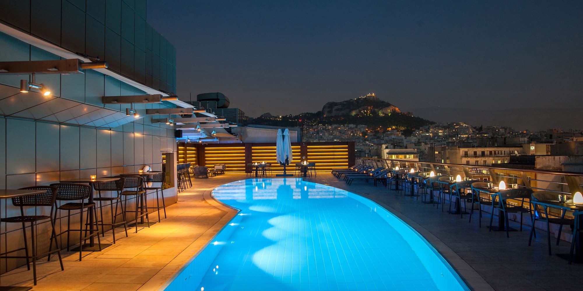 a pool with chairs and tables around it