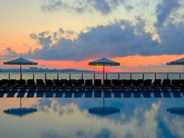 a pool with chairs and umbrellas