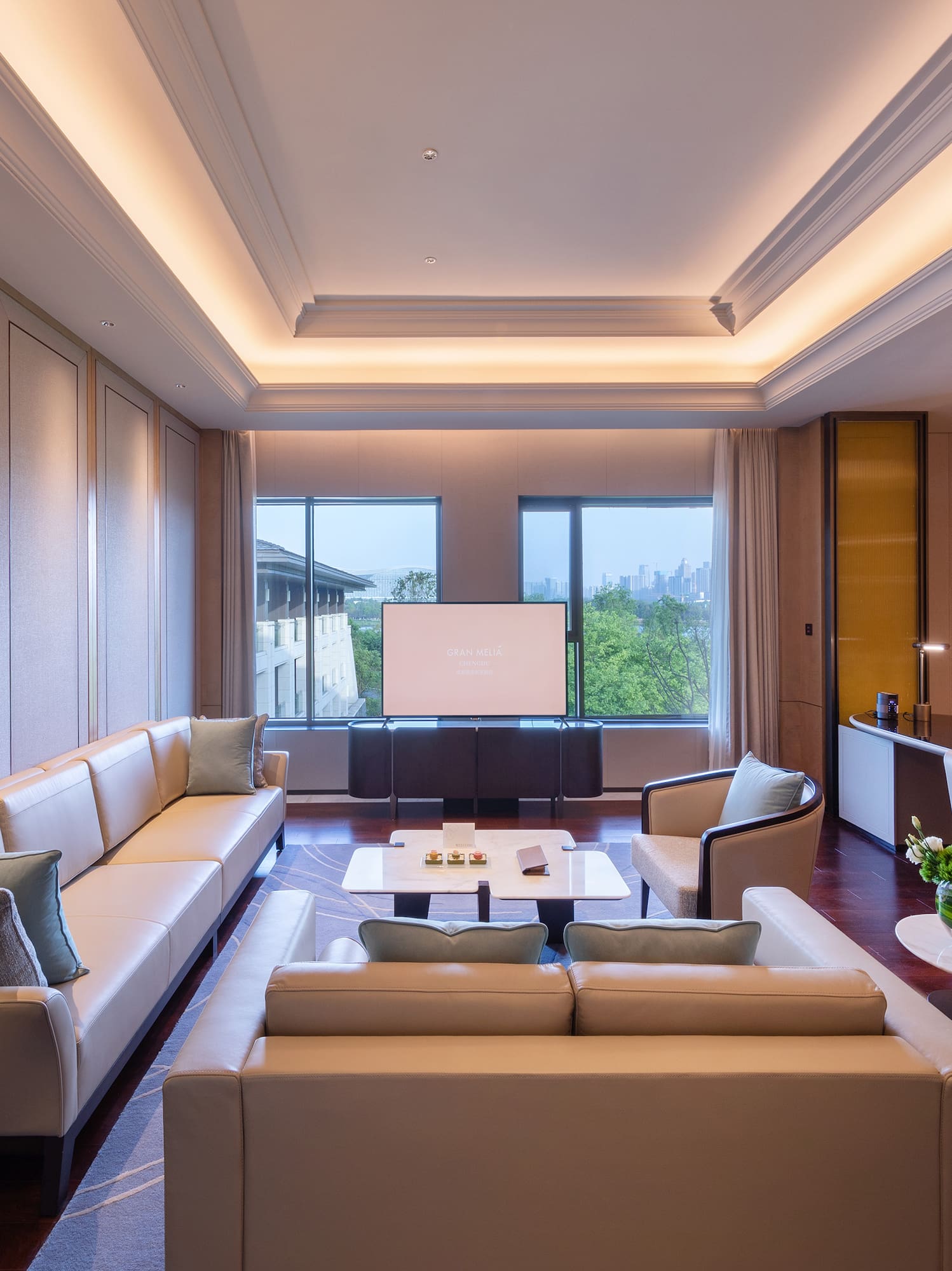 a room with white couches and a television