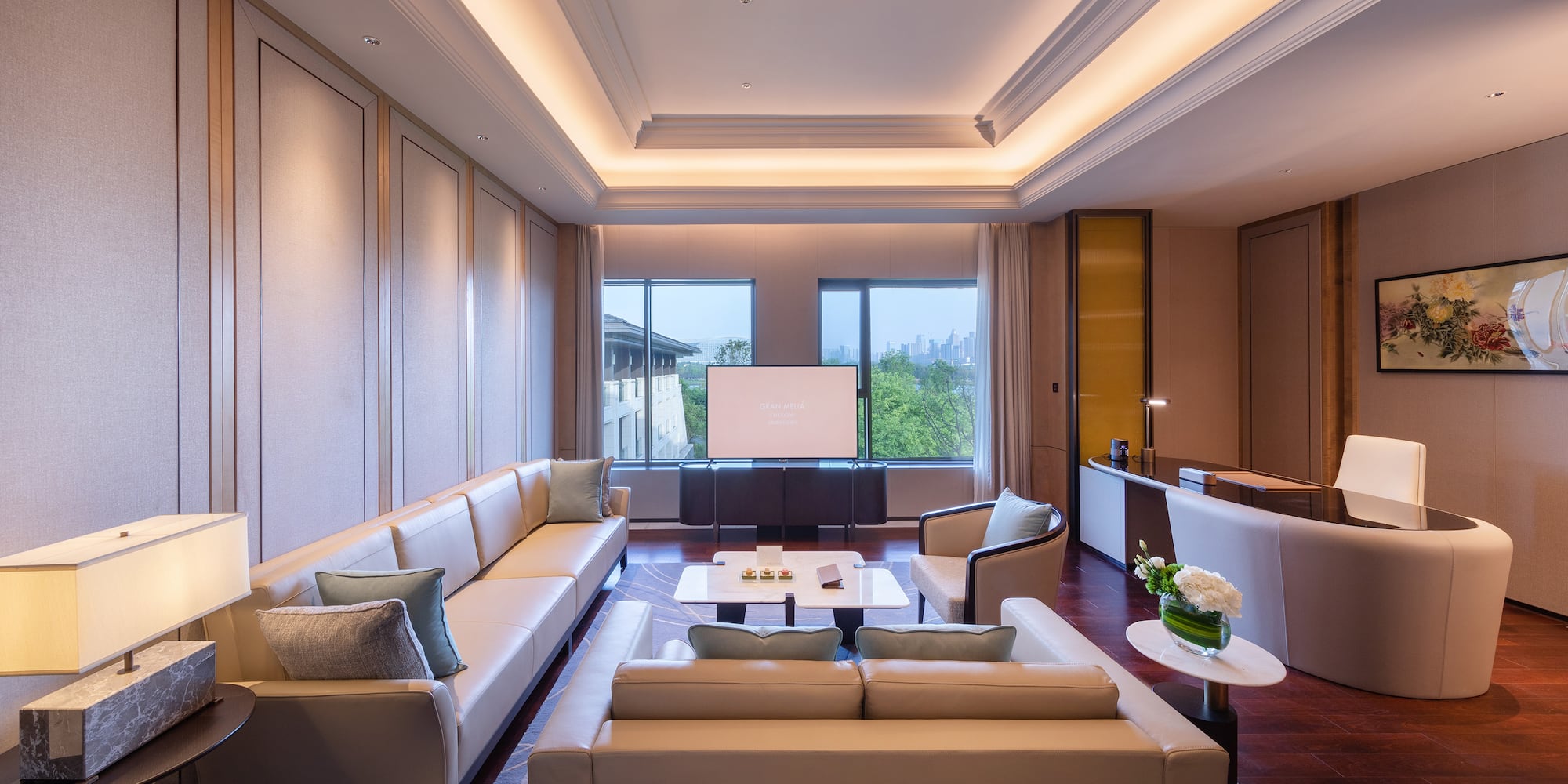 a room with white couches and a tv