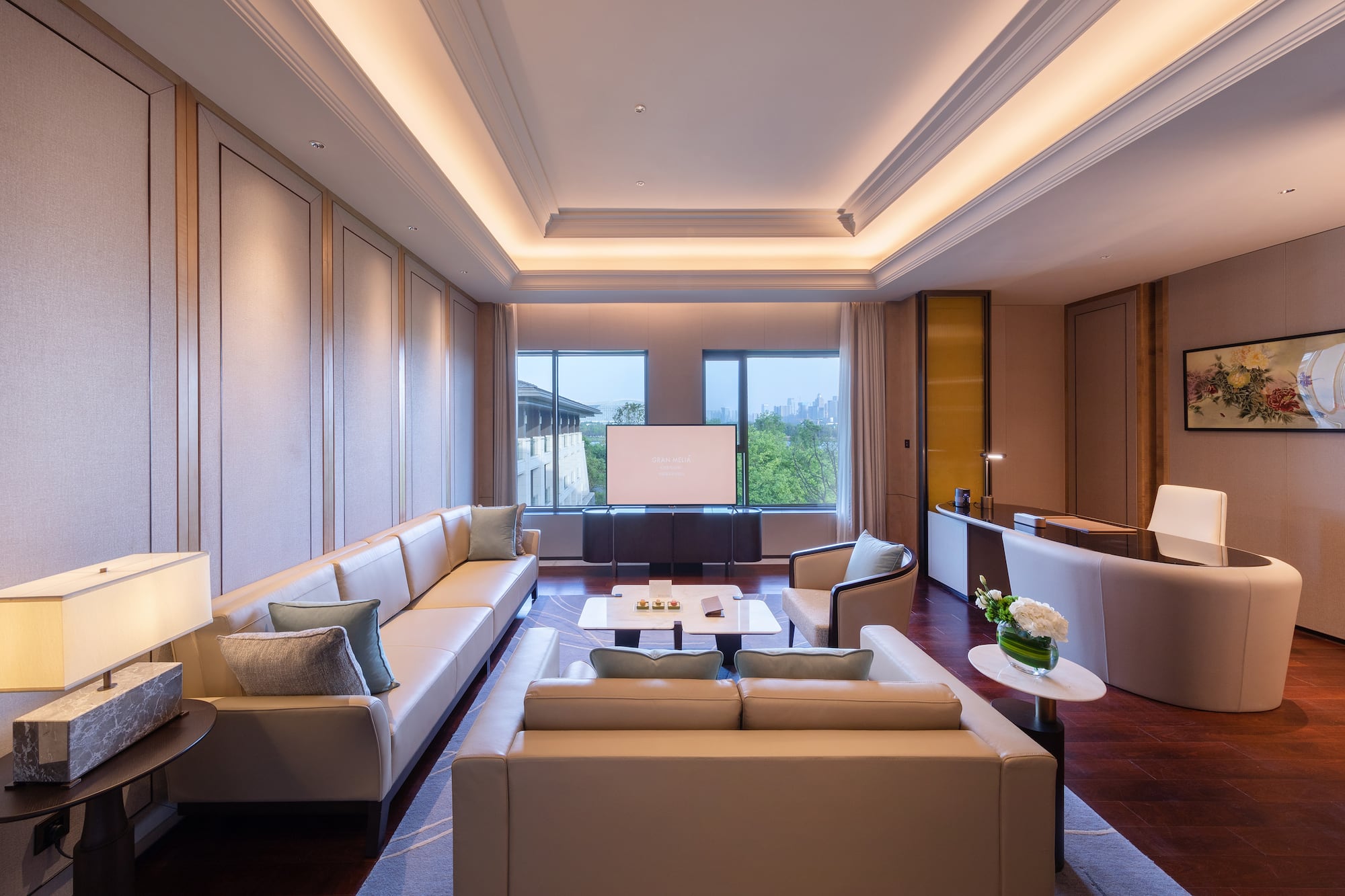 a room with white couches and a tv