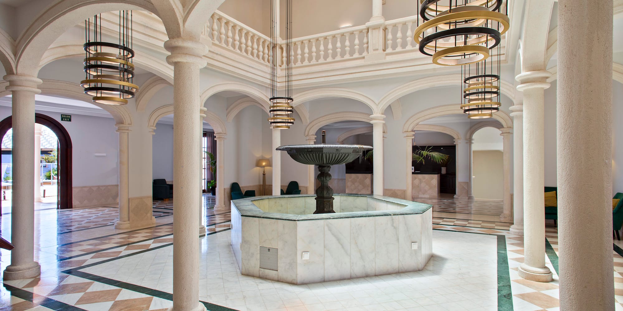 a large room with a fountain and columns