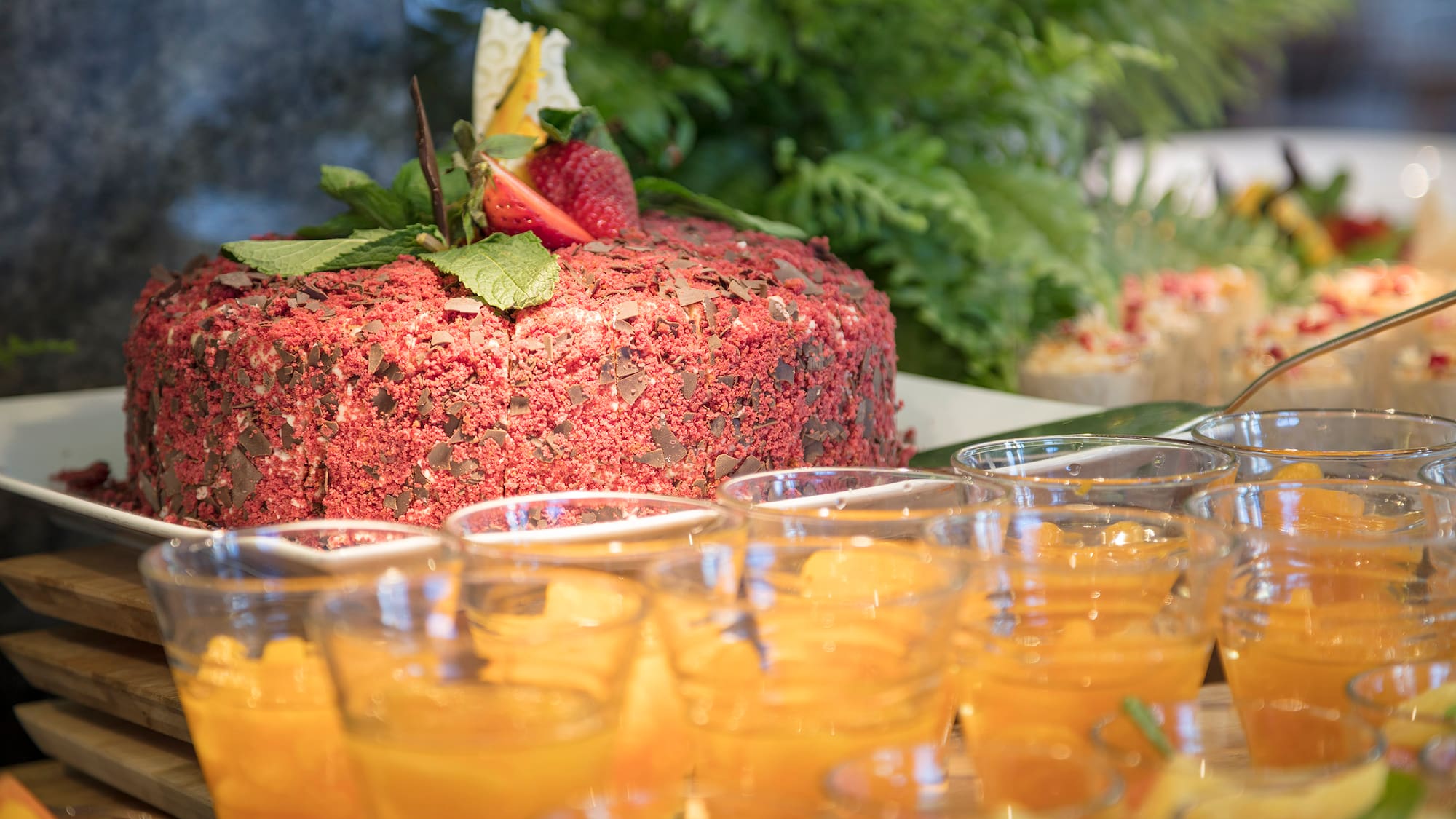 a table with a cake and glasses of orange liquid
