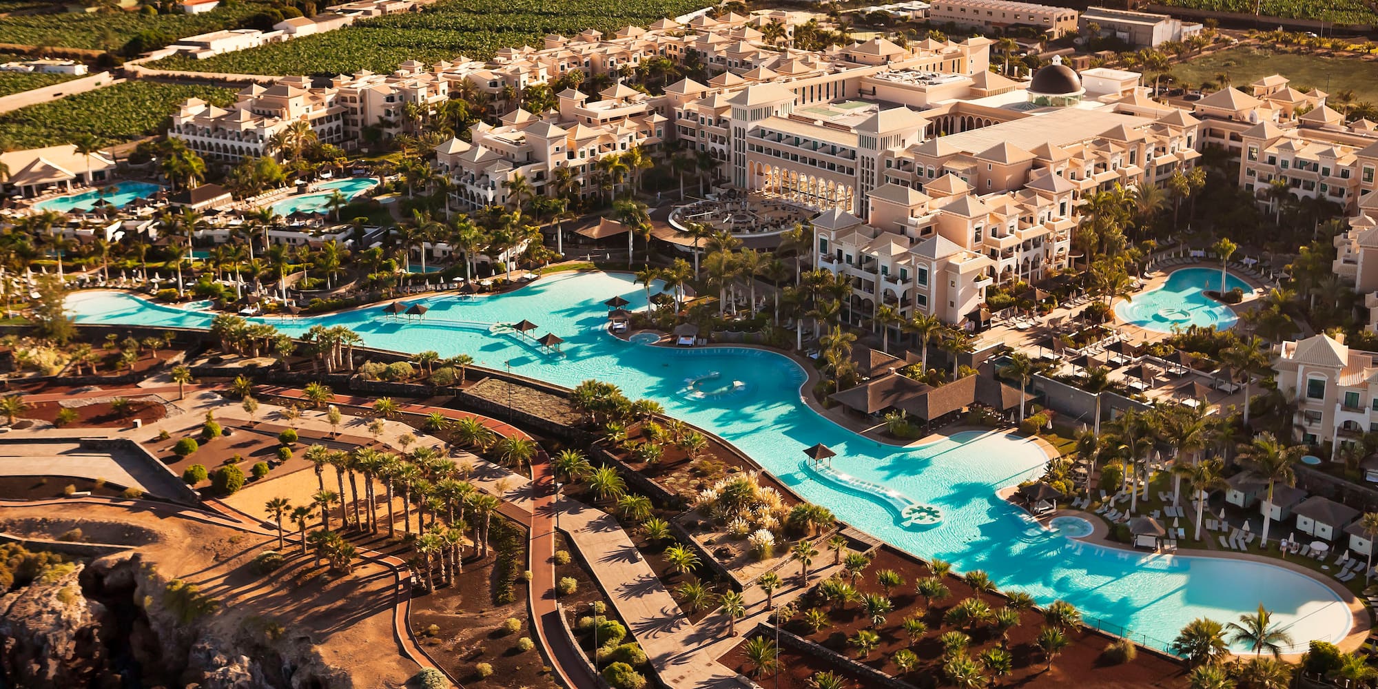 a large hotel with a pool and palm trees
