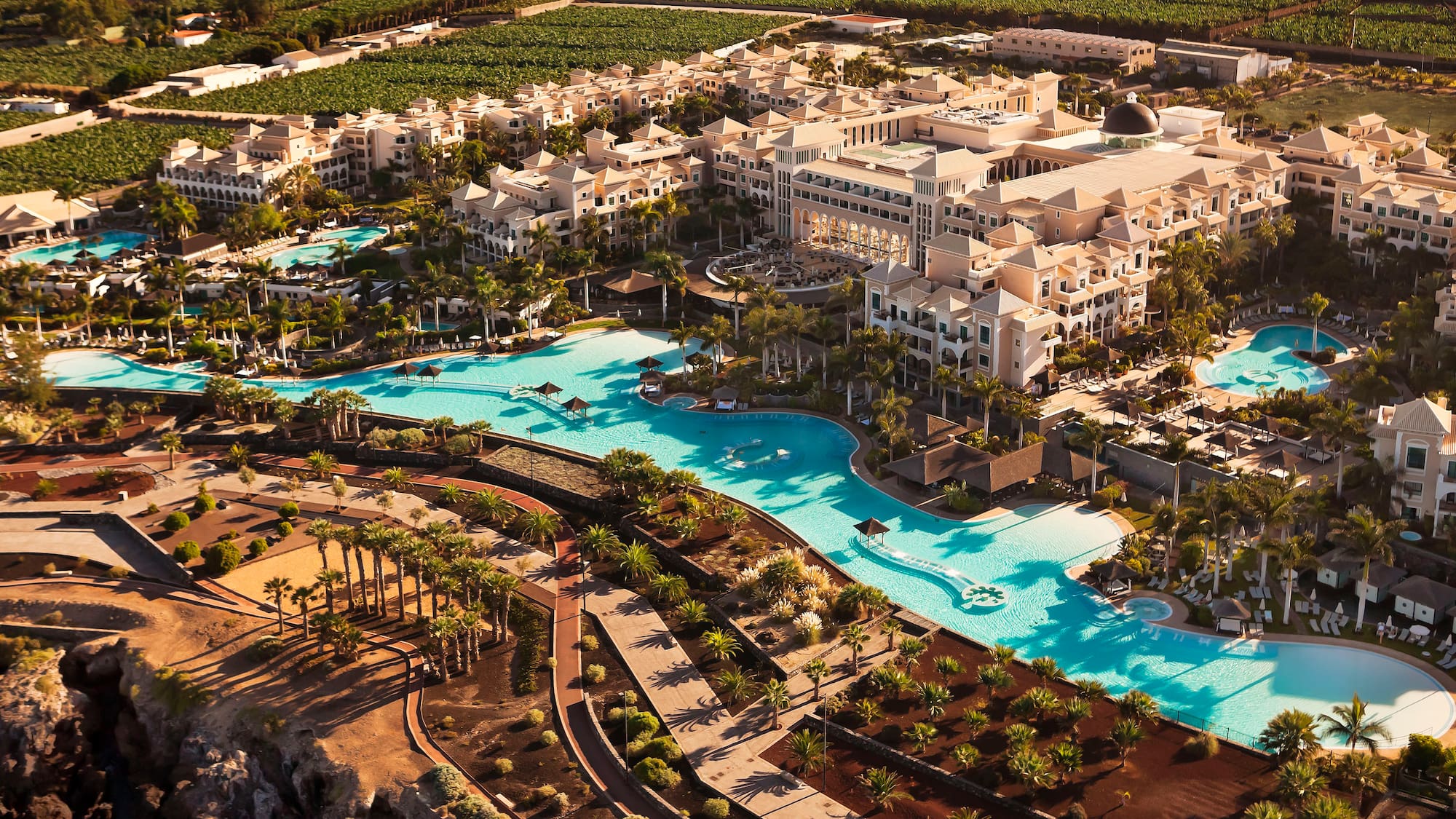 a large hotel with a pool and palm trees