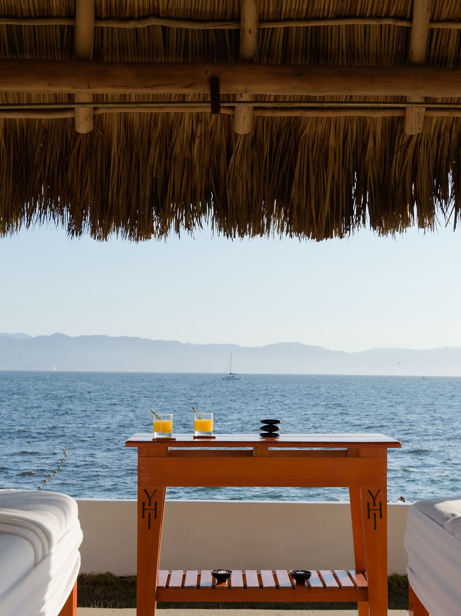 a table with drinks on it by a beach