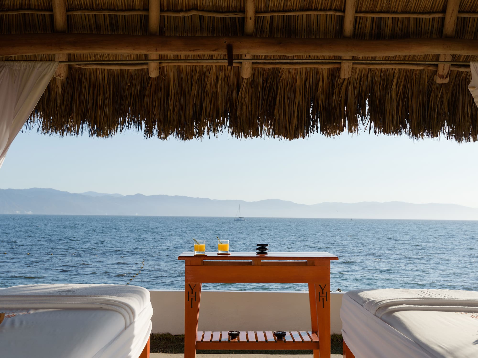 a table with drinks on it by a beach