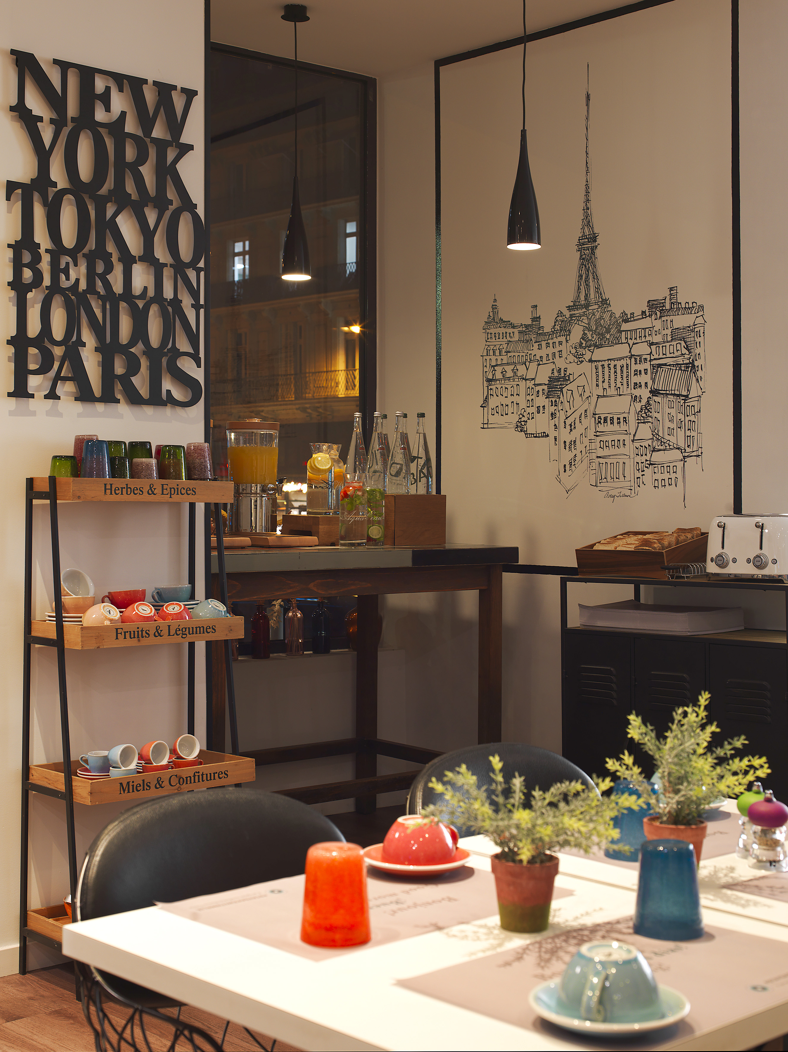 Global-themed breakfast buffet with juice, bread, colorful cups, and Parisian cityscape art.