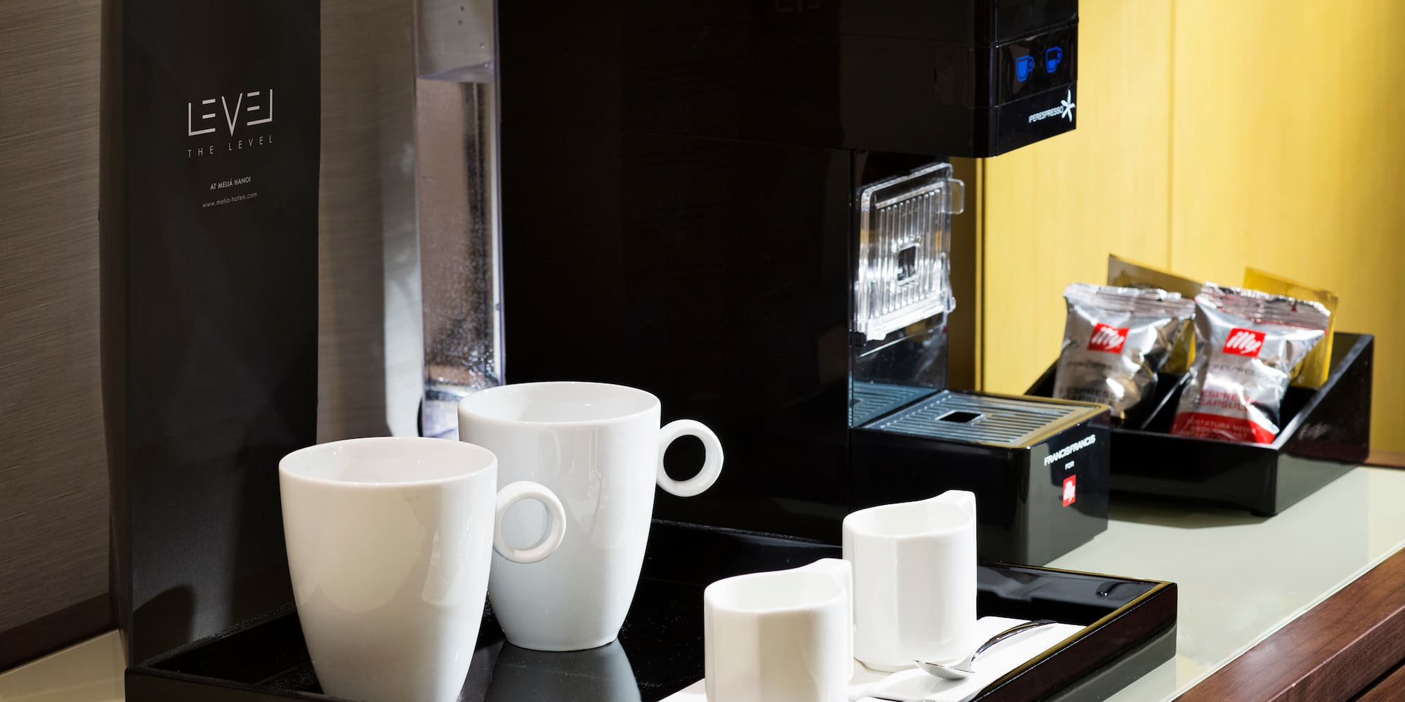 a coffee machine with cups on a tray