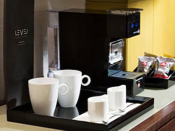 a coffee machine with cups on a tray
